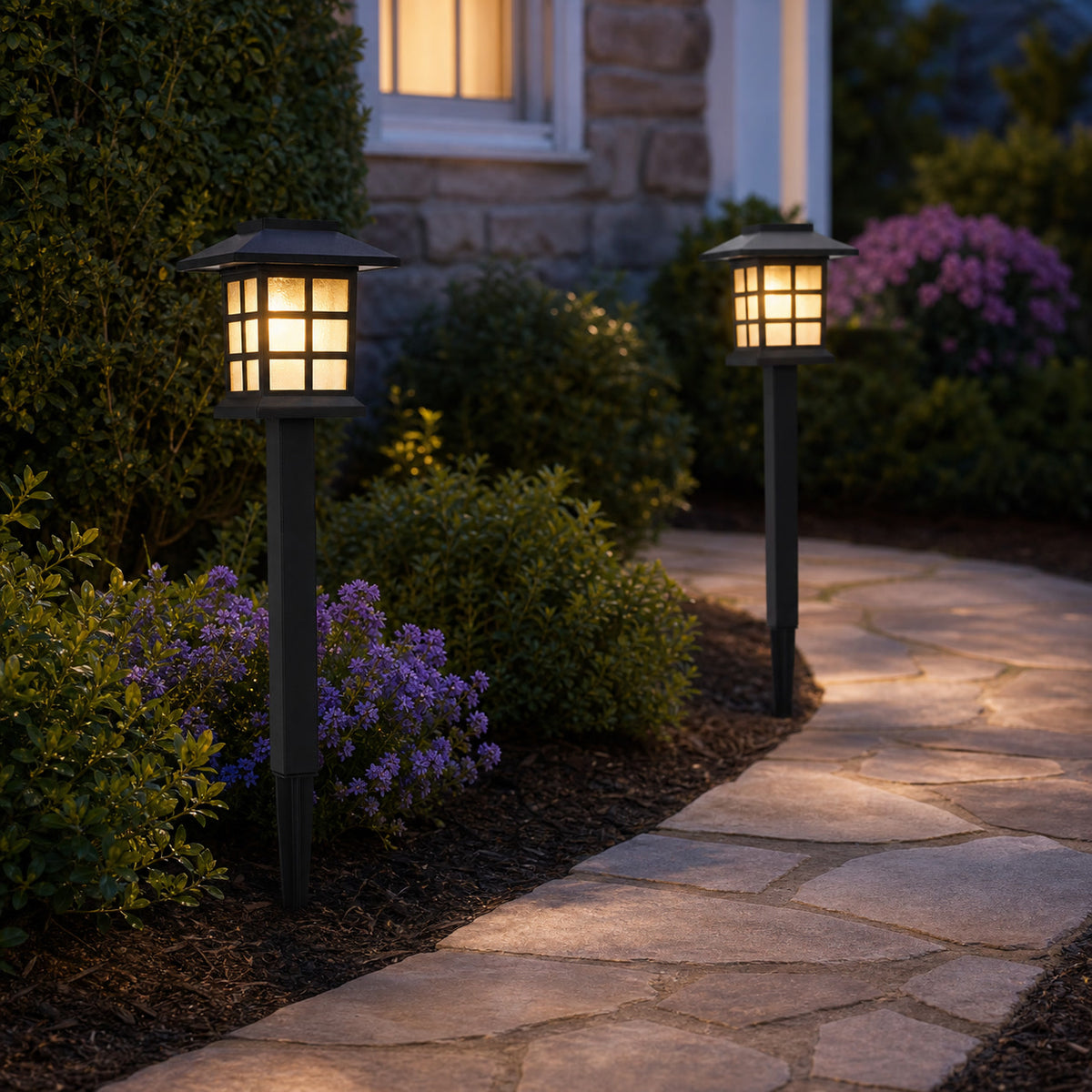 Solar cottage pathway lights glowing along a stone garden walkway at dusk