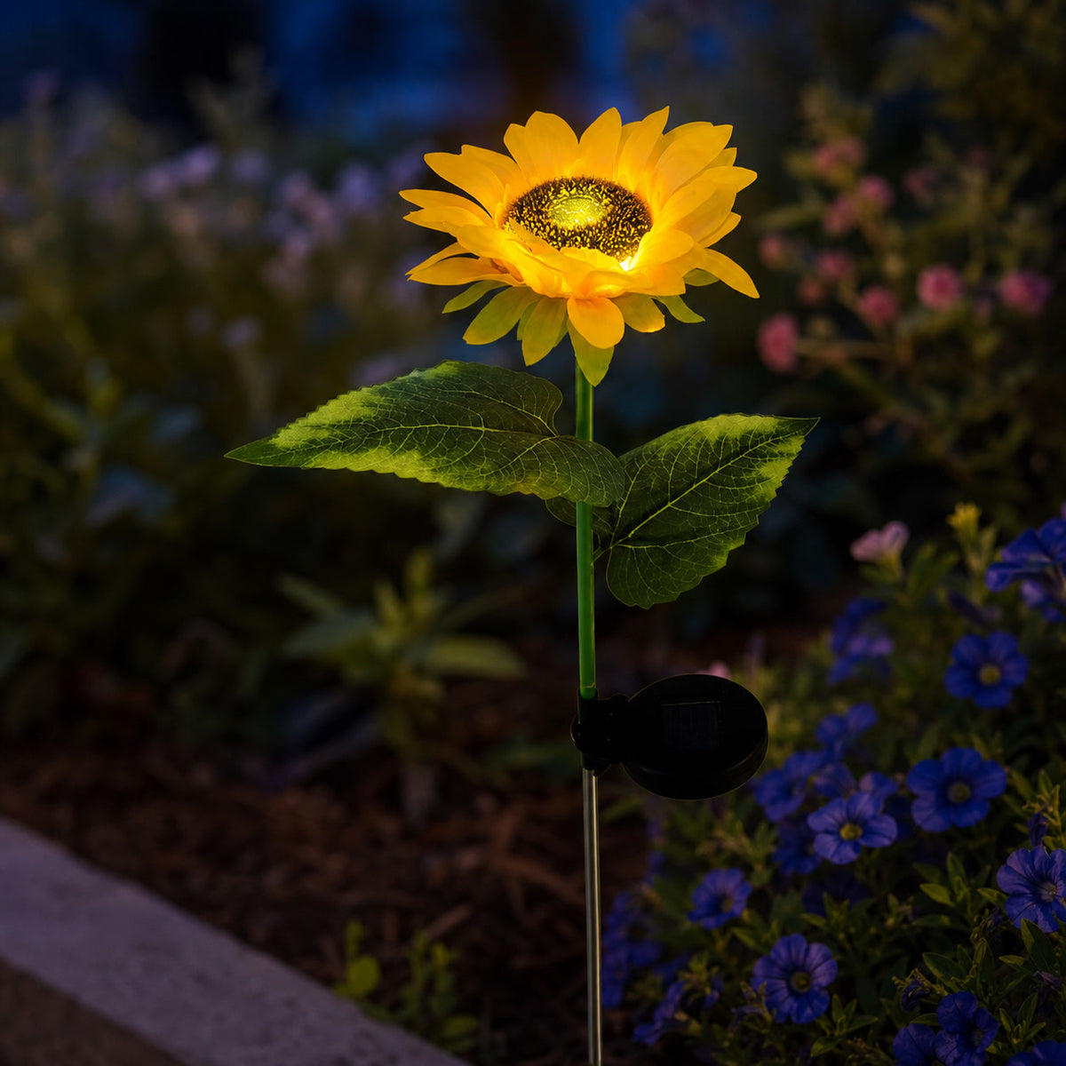 Solar sunflower garden light glowing gently in a flower bed at dusk