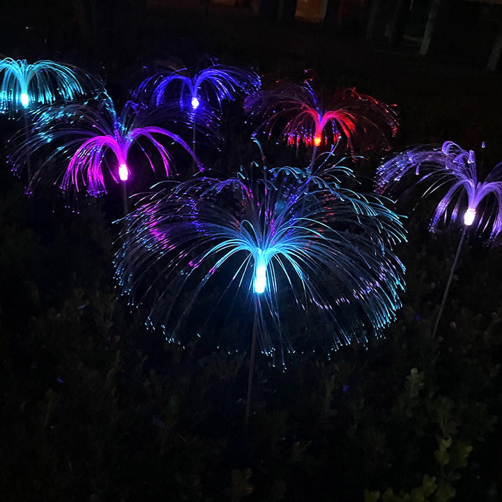 Solar jellyfish garden stakes glowing in multiple colors at night