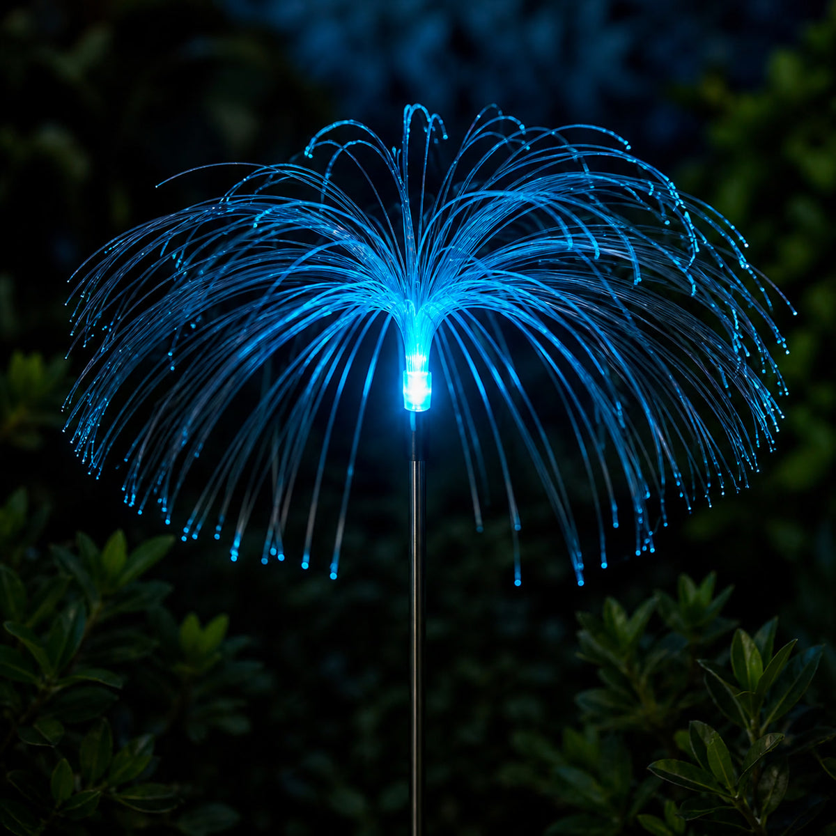 Close view of a blue solar jellyfish garden stake and its illuminated fiber strands